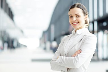 Genç ve güzel başarılı profesyonel iş kameraya bakarak çapraz kollu