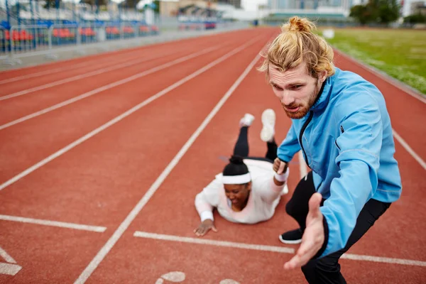 Ung Man Dragande Överdimensionerade Kvinna Ner Travet Mot Mållinjen — Stockfoto