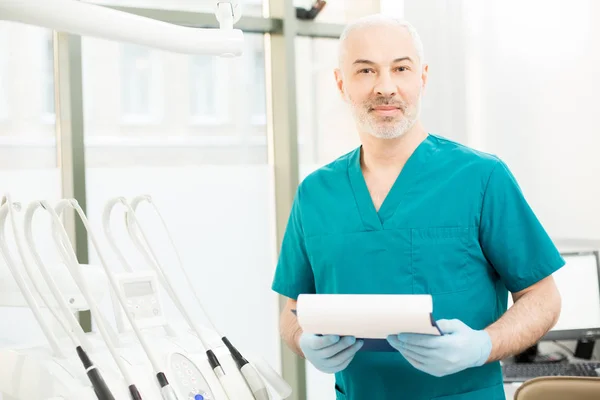 Dentista Envelhecido Uniforme Luvas Olhando Para Câmera Enquanto Estava Seu — Fotografia de Stock