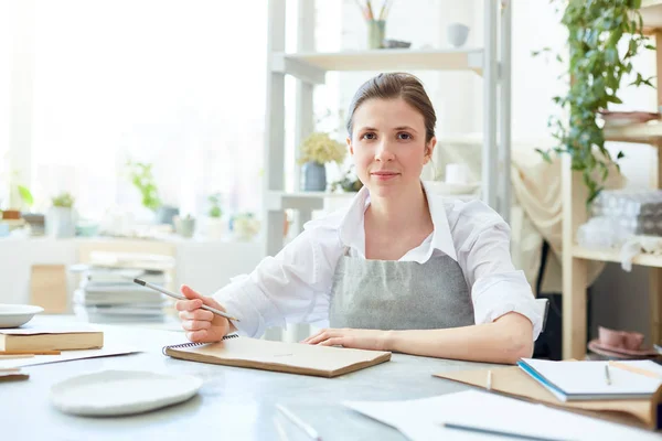 Mujer Joven Creativa Camisa Blanca Delantal Gris Sentada Junto Mesa — Foto de Stock