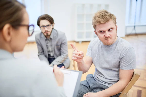 Jovem Homem Desconfiado Irritado Apontando Para Conselheiro Enquanto Conversa Com — Fotografia de Stock