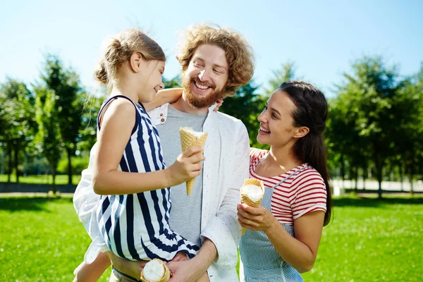 快乐的小女孩和她的父母与冰淇淋谈论和享受阳光明媚的一天在公园里 — 图库照片