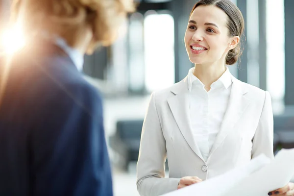 Elegante Mujer Negocios Mirando Compañero Trabajo Con Sonrisa Mientras Discute — Foto de Stock