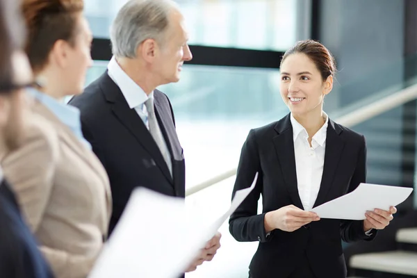 Junge Händlerin Mit Papier Beantwortet Fragen Des Business Teams Nach — Stockfoto