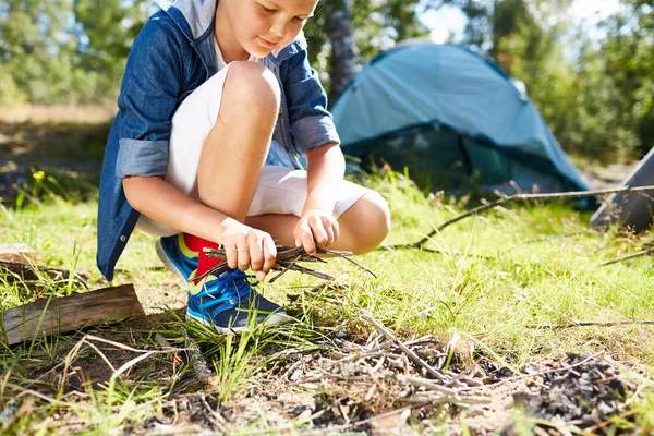 乾燥した枝の旅行中に草でキャンプファイヤーを作るつもりで若いボーイ スカウト — ストック写真
