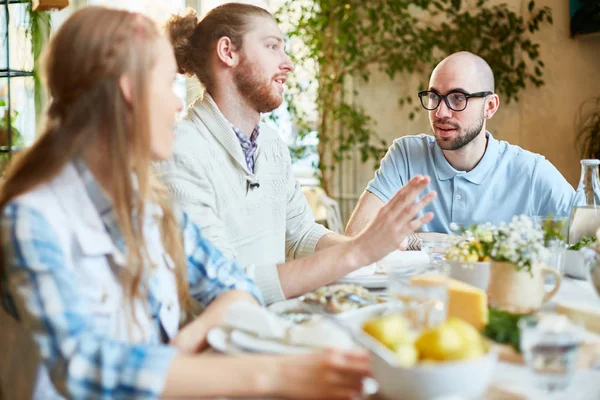 Uno Giovani Amici Raccontando Qualcosa Tavola Servita Durante Cena Riunirsi — Foto Stock