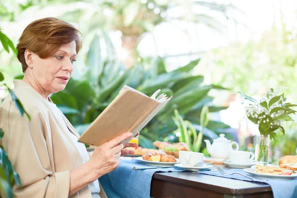 Anciana Leyendo Libro Por Mesa Servida Después Del Desayuno Mientras — Foto de Stock