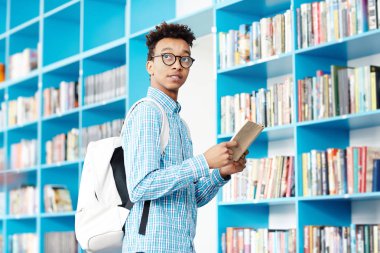 Kitap ve Kütüphane saat sonraki derse geç değil sırayla bakarak sırt çantası ile Afrikalı-Amerikalı öğrenci