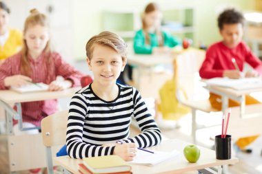 Çizgili kazak size resepsiyon tarafından oturan ve bireysel görevi taşıma sırasında bakıyor zeki öğrenci