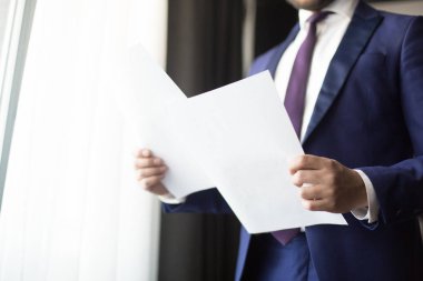 Finansal kağıtları veya ekonomist elinde sözleşmelerinde veya ajan takımı ayakta ofis pencere tarafından