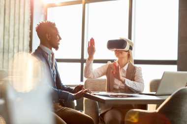 Afrikalı-Amerikalı işadamı vr genç kadın ile iletişim kafede toplantısında koruyucu gözlük