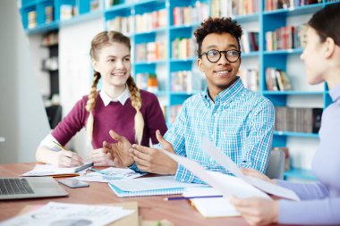 Mutlu erkek ve kız onların groupmate ev görev veya seminer kitaplığı için hazırlık tartışma sırasında