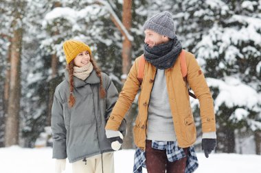 Kışın kar yağışı ormanda yürüyüş winterwear iki genç backpackers