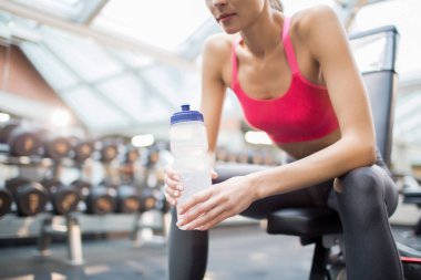 Plastik şişe su rahatlatıcı fitness Center'da eğitimler arasında olan aktif kadın