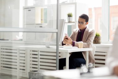 Onun işyerinde otururken cep telefonunu kullanarak iş adamı