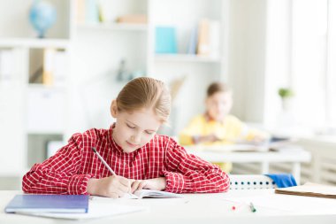 Not defterinde tarafından sınıf masasında otururken çizim kalem ile zeki kız öğrenci
