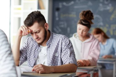 Sorular sınav test kağıt üzerine bakarak ve onlardan cevap hatırlamaya çalışarak dalgın adam