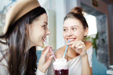 Dondurma en iyi başka bir içki paylaşırken görünümlü lezzetli kokteyl bir cam çubuk ile mutlu kızlar