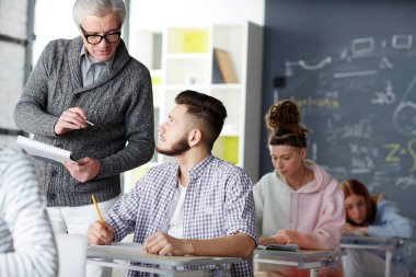Bir öğrencinin ders konuşuyor ya da ona soru soran kıdemli Profesör
