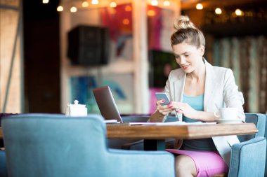 Kafede otururken istemciye okuma bildirim veya manifatura smartphone ile genç mutlu erkek