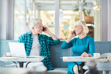 Telefonlarında konuşma ve başka bir gülümseme ile seyir iki mutlu iş ortağı