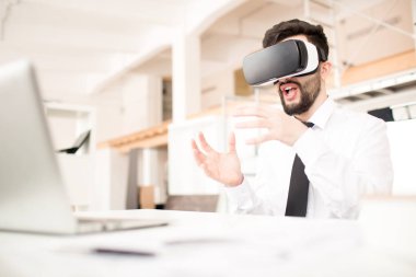 Sanal gerçeklik gözlüklü masada oturan işadamı. O el hareketi ve söz