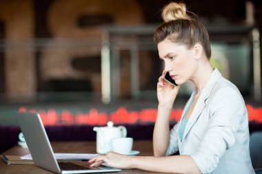 Genç ciddi çalışan online proje ya da yeni Web sitesi tarafından smartphone konuşurken eğitim üzerinde konsantre