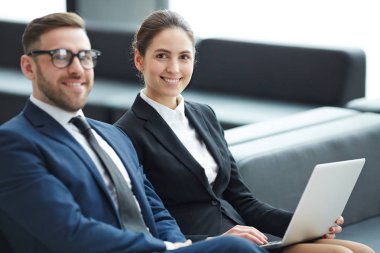 Havaalanı lounge alanında oturup ve net bilgi arayan takım elbiseli başarılı brokerları