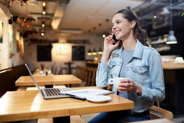 Kahve içme sırasında konuşma cep telefonu ile konuşurken sahip sevimli gülümseme ile çekici erkek