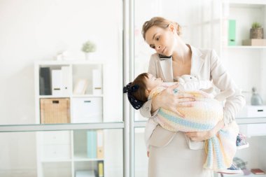 Uyuyan bebek kızı yanında smartphone Office konuşurken tutan genç iş anne