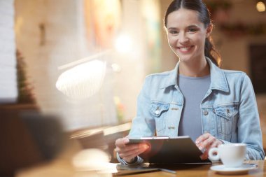 Kafede oturan belge ile gülümseyen kadın portresi