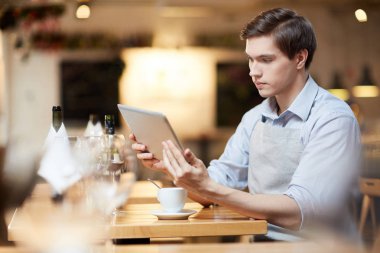 Dijital tablet kullanarak kafede garson. Siparişler online kontrol ediyor