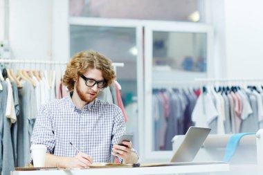 Seyir onun telefon ve notlar masada oturan genç işadamı