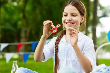 Beyaz pamuklu bluz yaz günü topluca spinner Park oynamaktan mutlu ve kaygısız kız