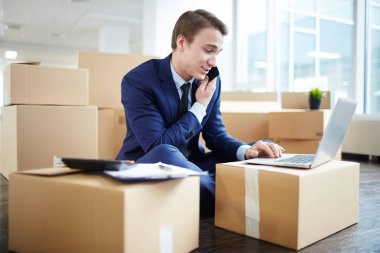 Paketleri arasında office katta oturan, istemci ile smartphone ile konuşmak ve net bilgi okuma elbiseli Genç Ajan