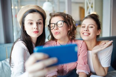 Üç sevimli coquettes selfie önünde smartphone için mola sırasında veya işten sonra poz