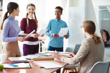 Üç başarılı öğrenciler öğretmenleri önünde duran ise seminerde raporları yapma