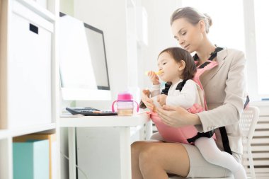 Genç iş anne bebek kızı Ofis İşyeri tarafından meyve yüzlü ile besleme