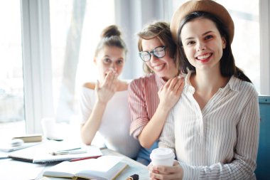 İçki ve Cafe masa başına oturmuş ve sınıflar arasında sonu zevk gülen arkadaşları ile mutlu zarif kadın