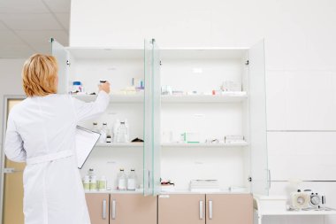 Profesyonel bir eczacı bir koridordaki bir yerel eczane stok kontrol fotoğrafı