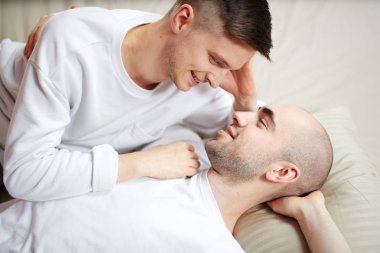 Yatağa rahatlatıcı ve başka bir şefkatle bakarak genç gay âşıklar