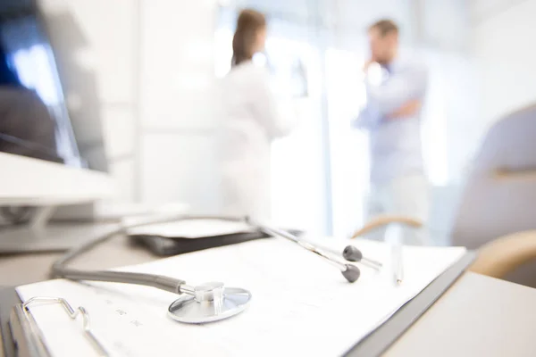 Klinisyen Tıbbi Belge Üzerinde Arka Plan Üzerinde Konuşurken Iki Doktor — Stok fotoğraf