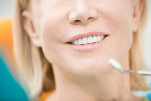 成熟的病人和牙科镜子附近的白色和健康的牙齿 — 图库照片