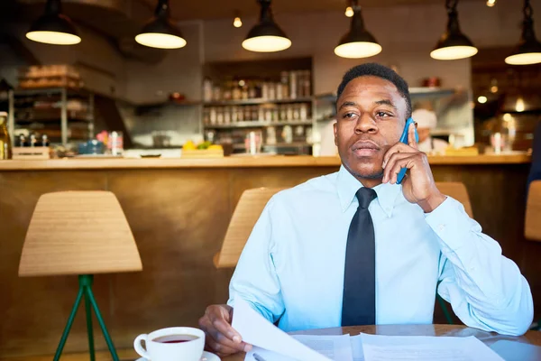 Jovem Agente Negócios Especificando Hora Nomeação Pelo Telefone Enquanto Sentado — Fotografia de Stock