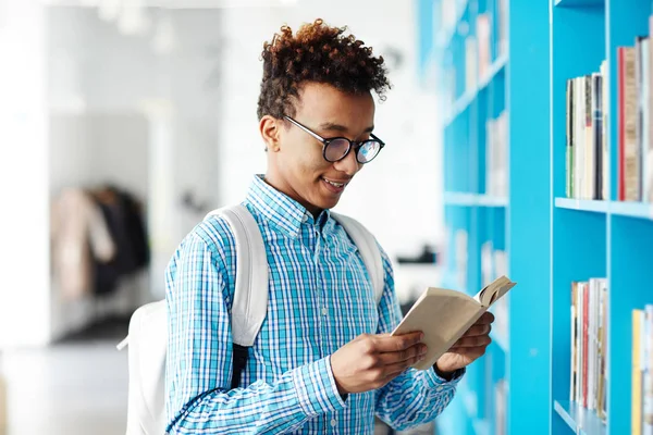 Gelukkig Afro Amerikaanse Tiener Casualwear Lezen Boek Terwijl Door Boekenplank — Stockfoto