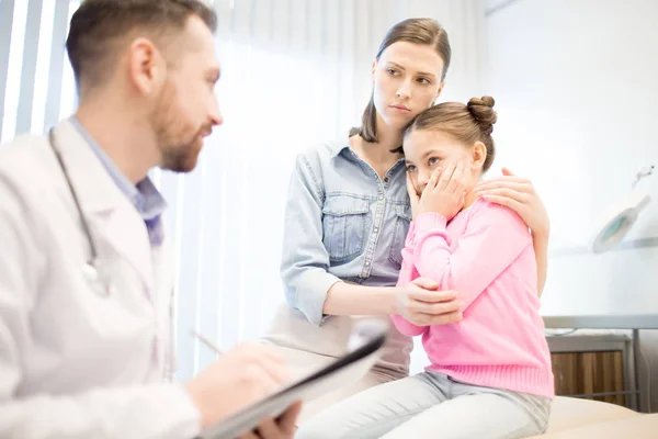 焦急的妇女和她的女儿听医生的意见在任命期间诊断 — 图库照片