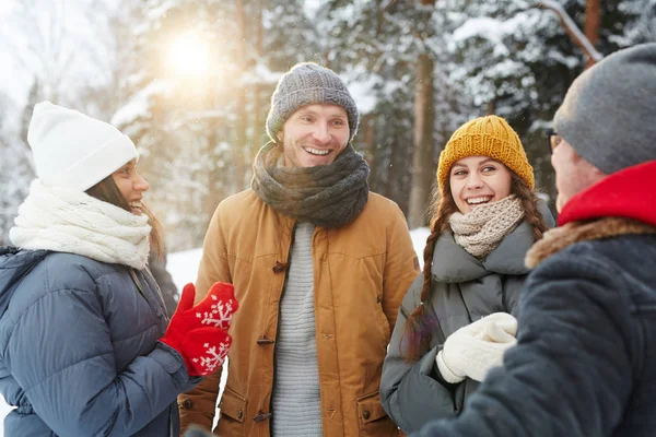 Winterwear の森の雪の日に話を持っていることで若い陽気な友人のグループ — ストック写真