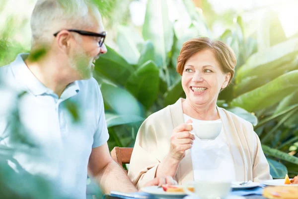 快乐的老女人喝早餐 并与她的丈夫在家里花园交谈 — 图库照片