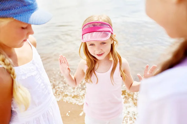 조끼와 분홍색 야구에 여자의 물가로 해변에서 그녀의 동료에 — 스톡 사진