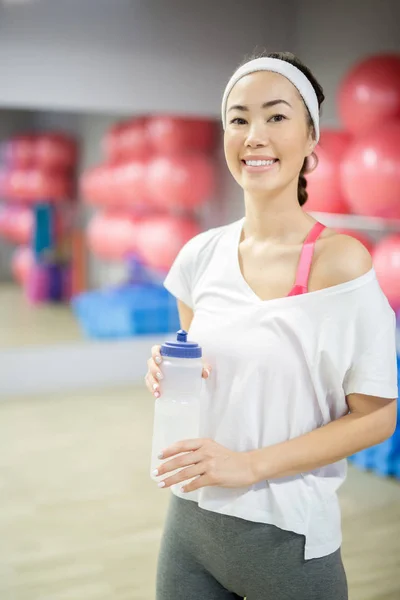 快乐女孩与塑料瓶水有断裂在体育俱乐部训练之间 — 图库照片
